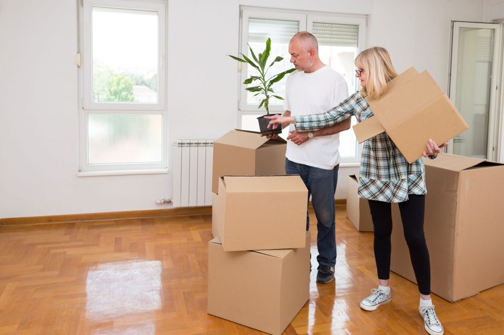 An older couple carrying a plant and packing up their belongings into boxes for UltraStor.