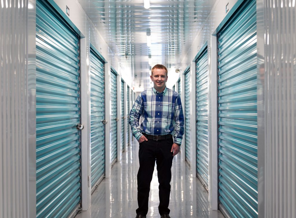 Member of the UltraStor team standing in a hallway of self-storage lockers.